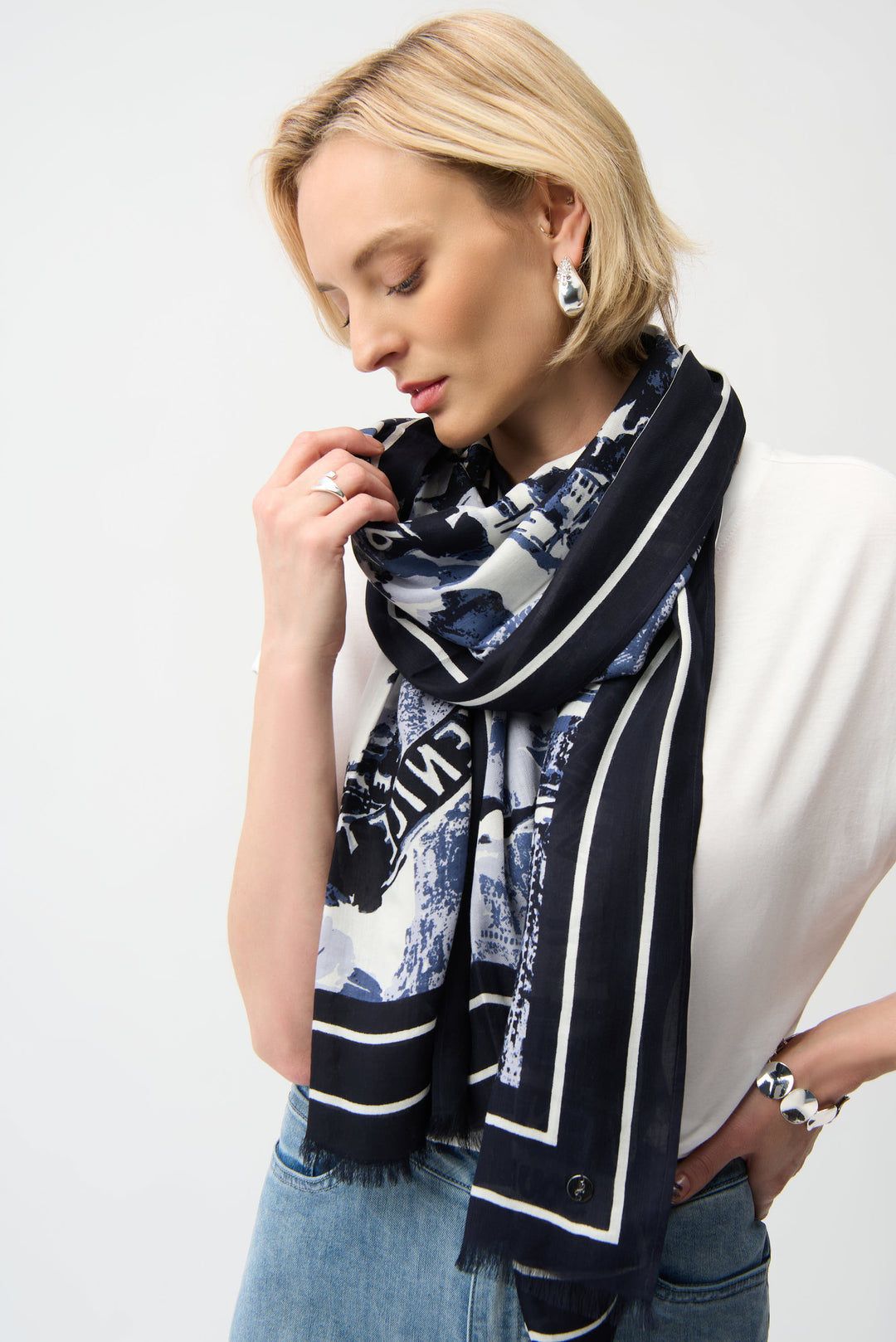 Woman wearing a black and white patterned scarf on a plain background