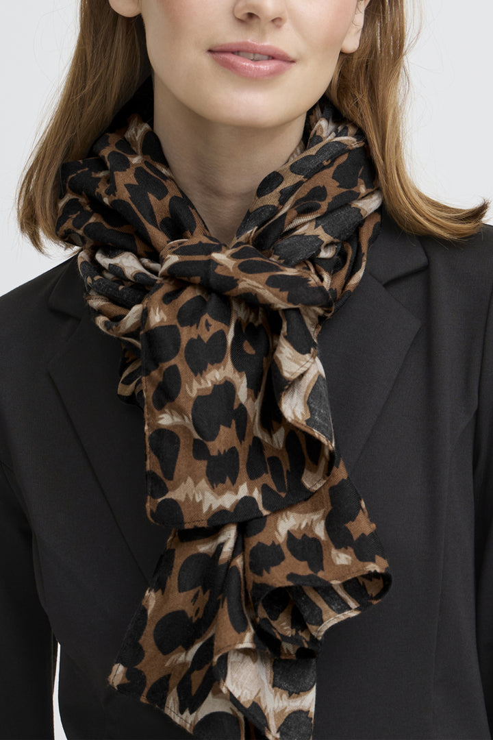Person wearing a leopard print scarf with a plain background