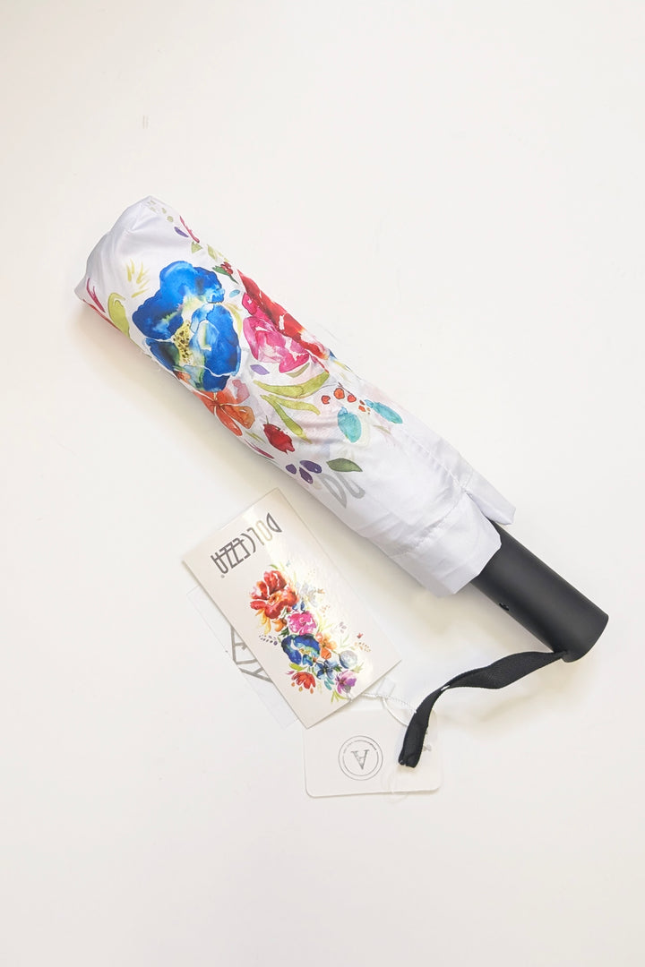 Foldable umbrella with watercolor floral design and Dolcezza tag on a light gray background