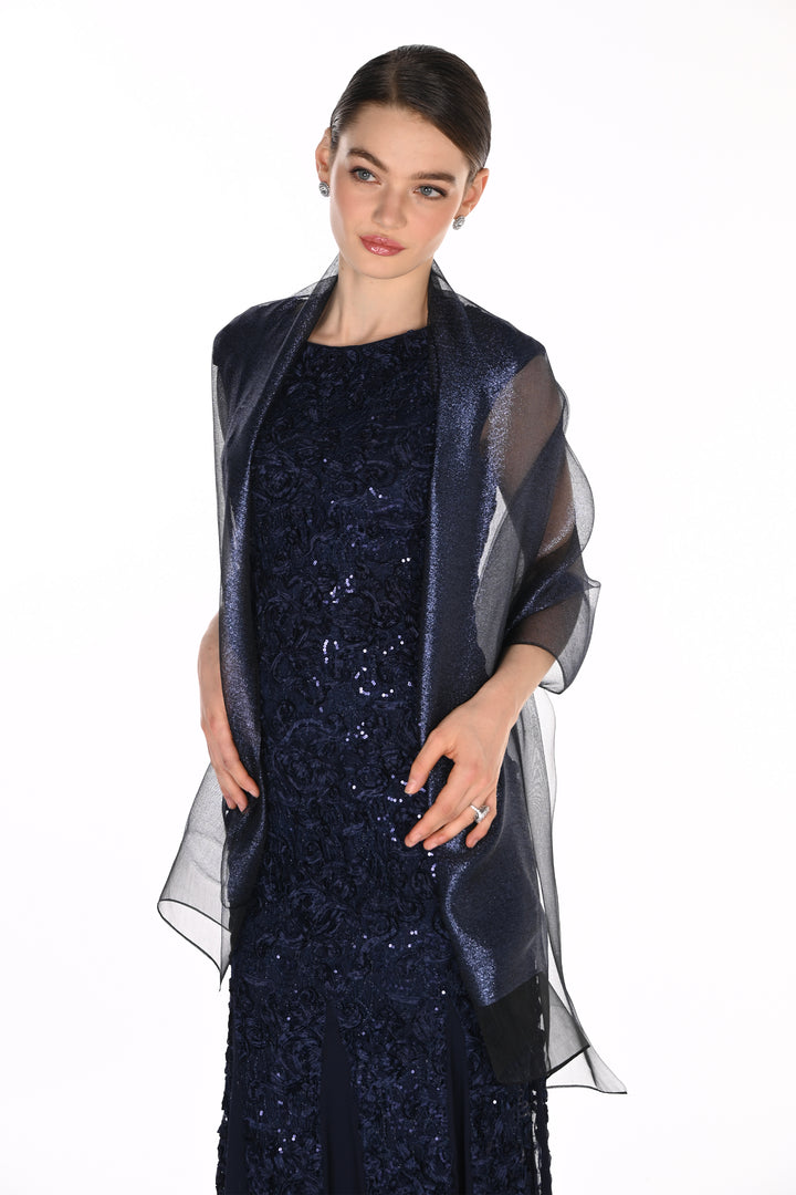 A woman modeling a dark navy blue sequined dress with a sheer, shimmering navy blue wrap or shawl draped over her shoulders, set against a plain white background.