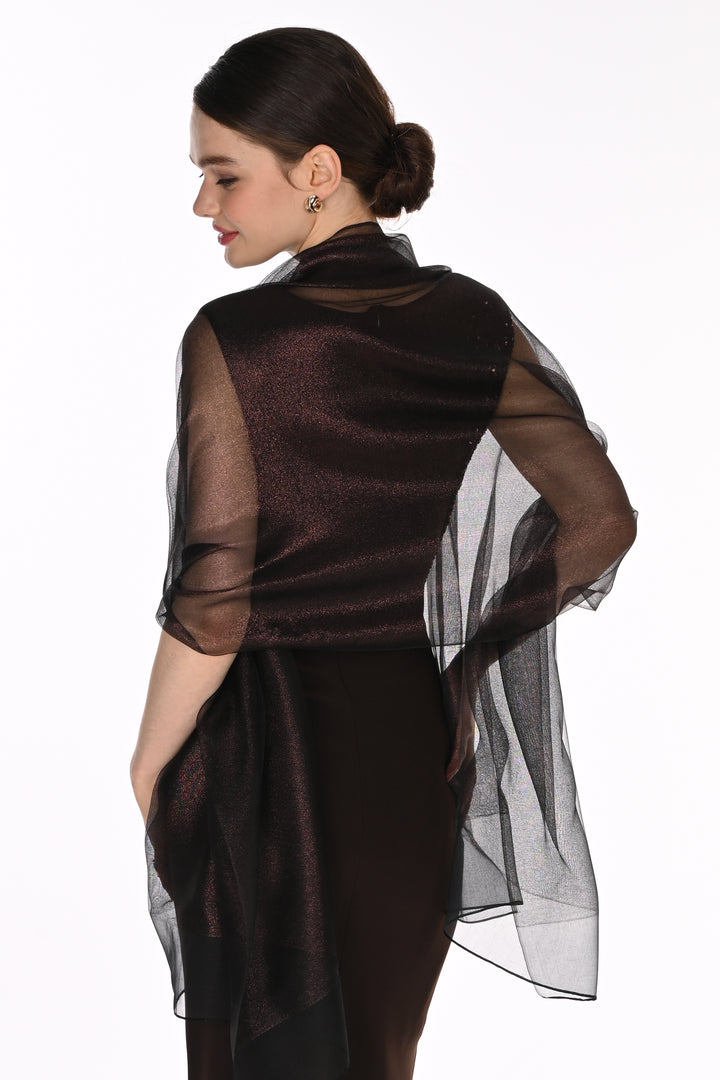 A woman shown from the back wearing a sheer, shimmering dark brown organza cape over a black dress against a plain white background.