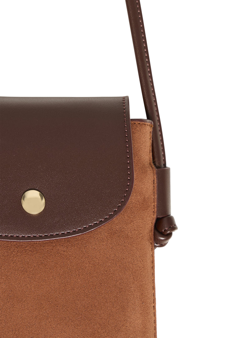 Close-up of a brown suede and dark brown leather crossbody bag with a gold snap button and a dark brown strap, shown against a plain white background.