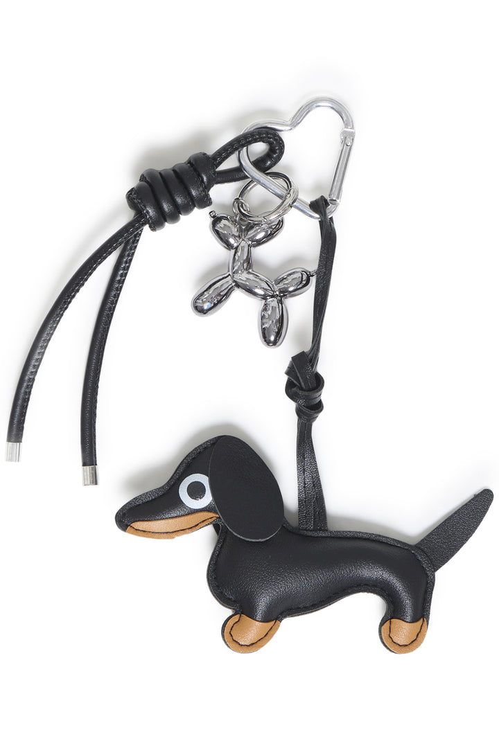 A black dog bag charm shown against a white background. 