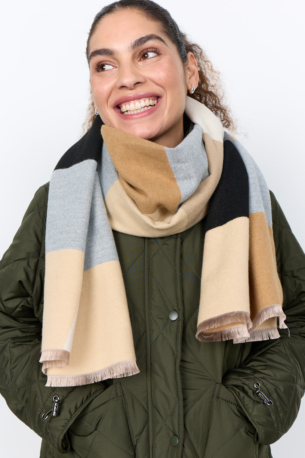 A woman wearing a bulky square patterned scarf