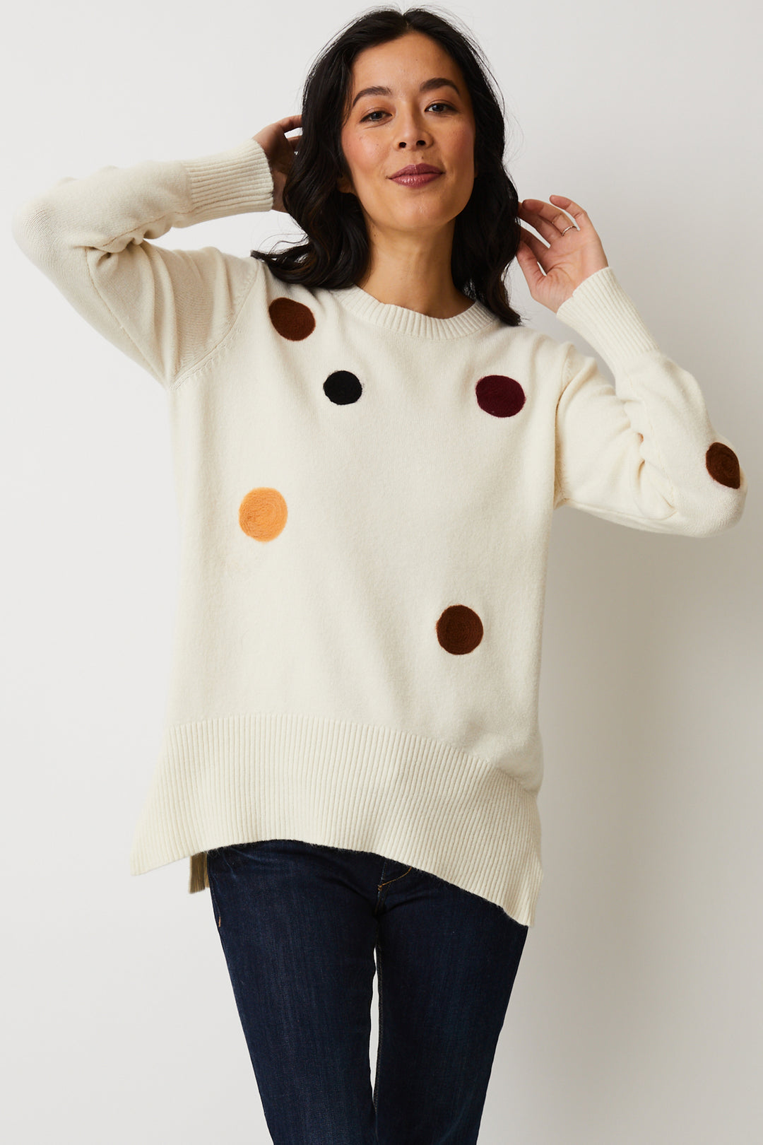 Cutely scattered polka dots and a lower bottom seam combine with full length sleeves and a light, relaxed fit for an eye-catching look. 