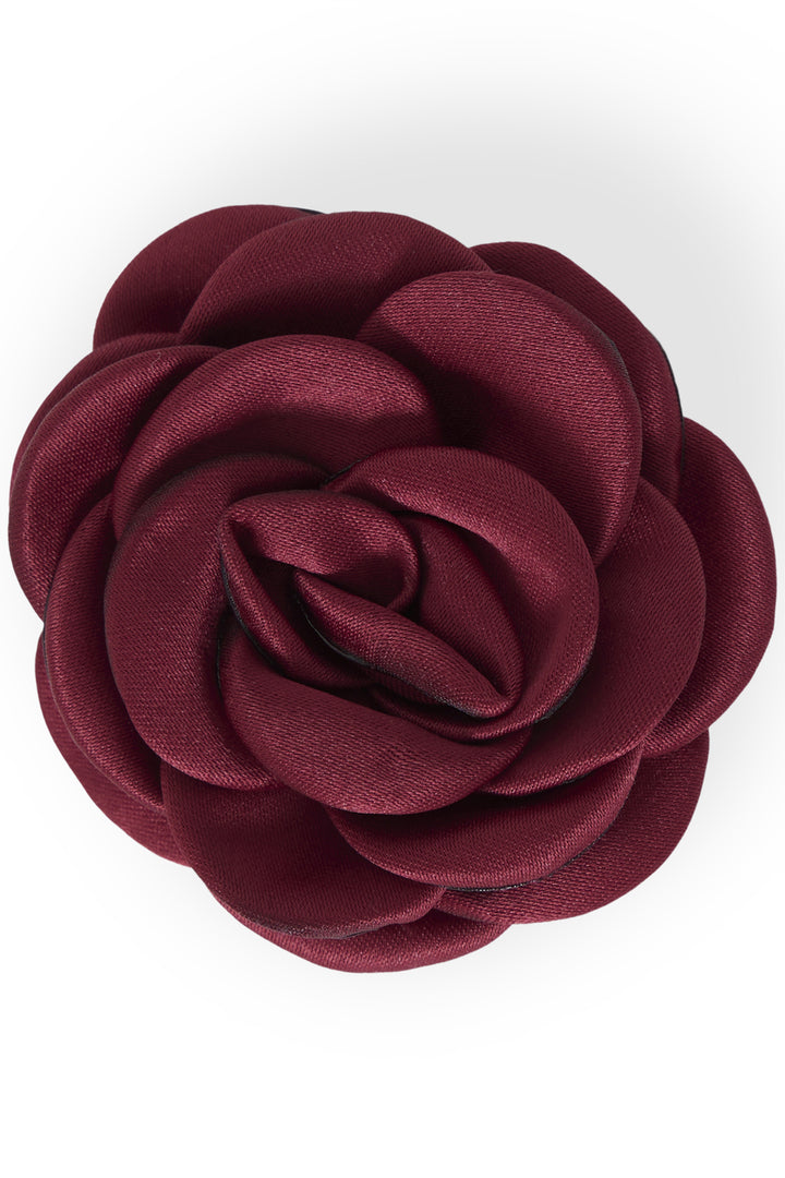 A large fabric rose flower accessory in a deep burgundy color, photographed from a top-down view on a white background.