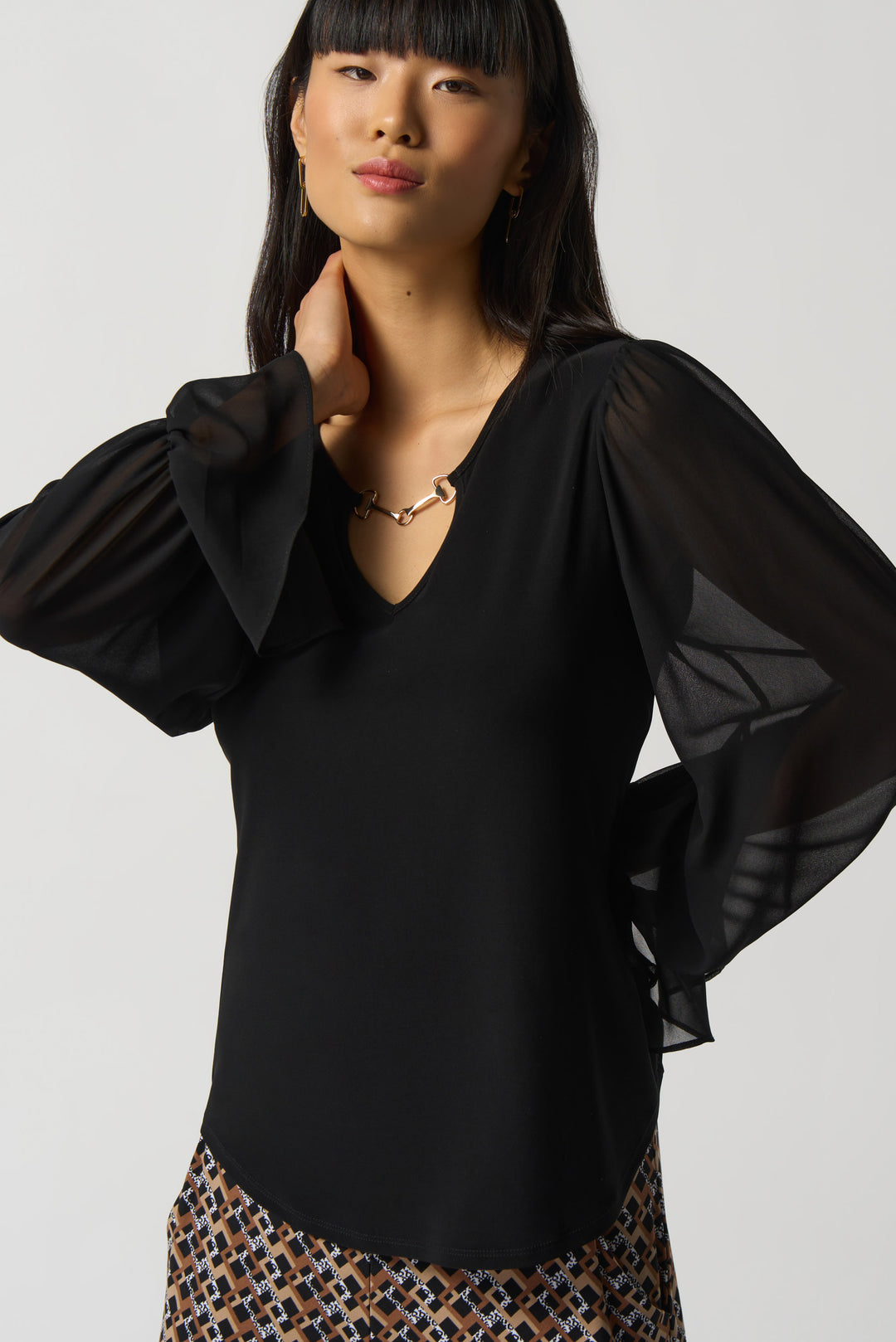 Crafted from a silky knit fabric, this top stands out with its fancy chiffon sleeves and overall looser fit. 
