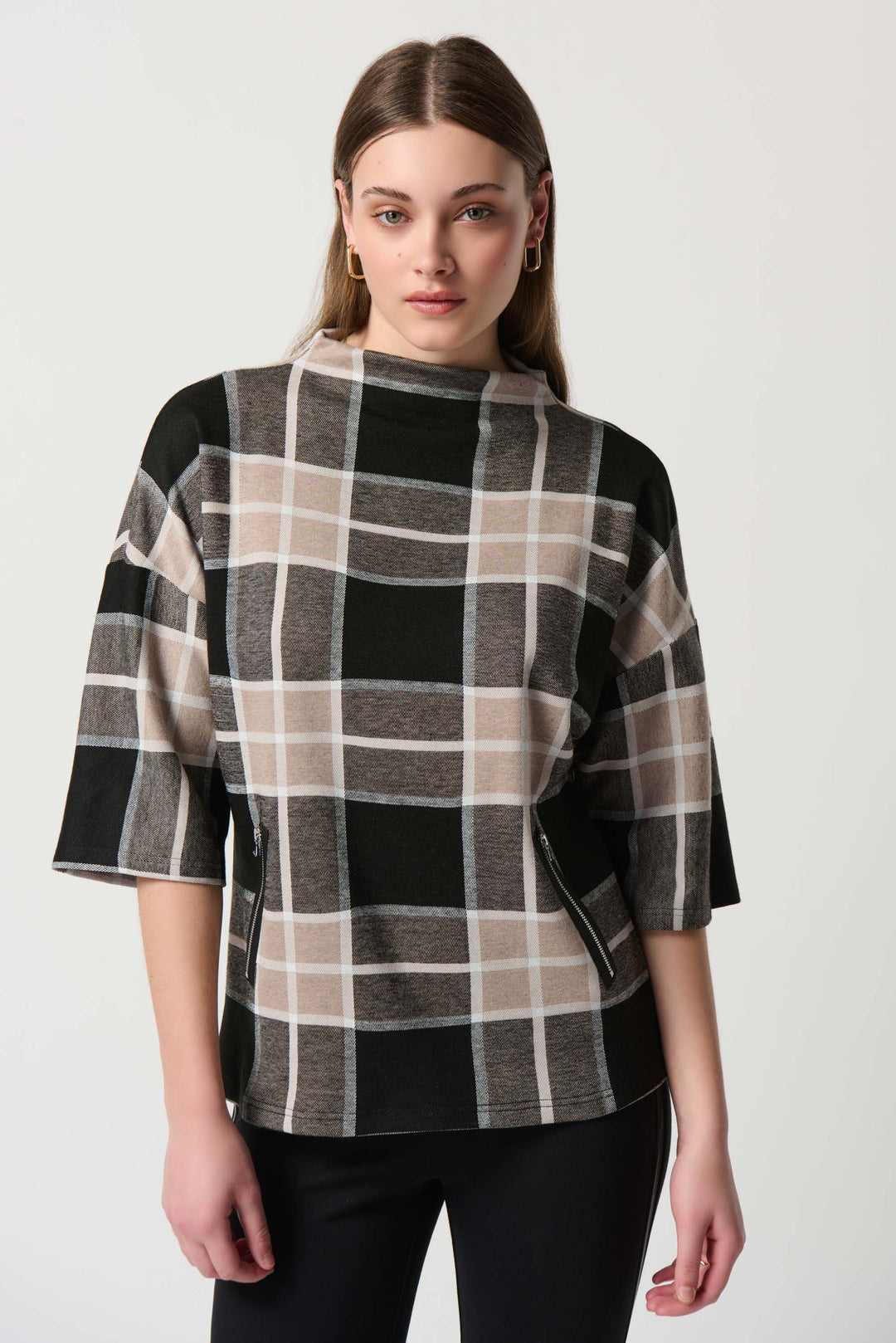 Its trendy knit design features a classic plaid print, a mock neck and a front zipper detail. 