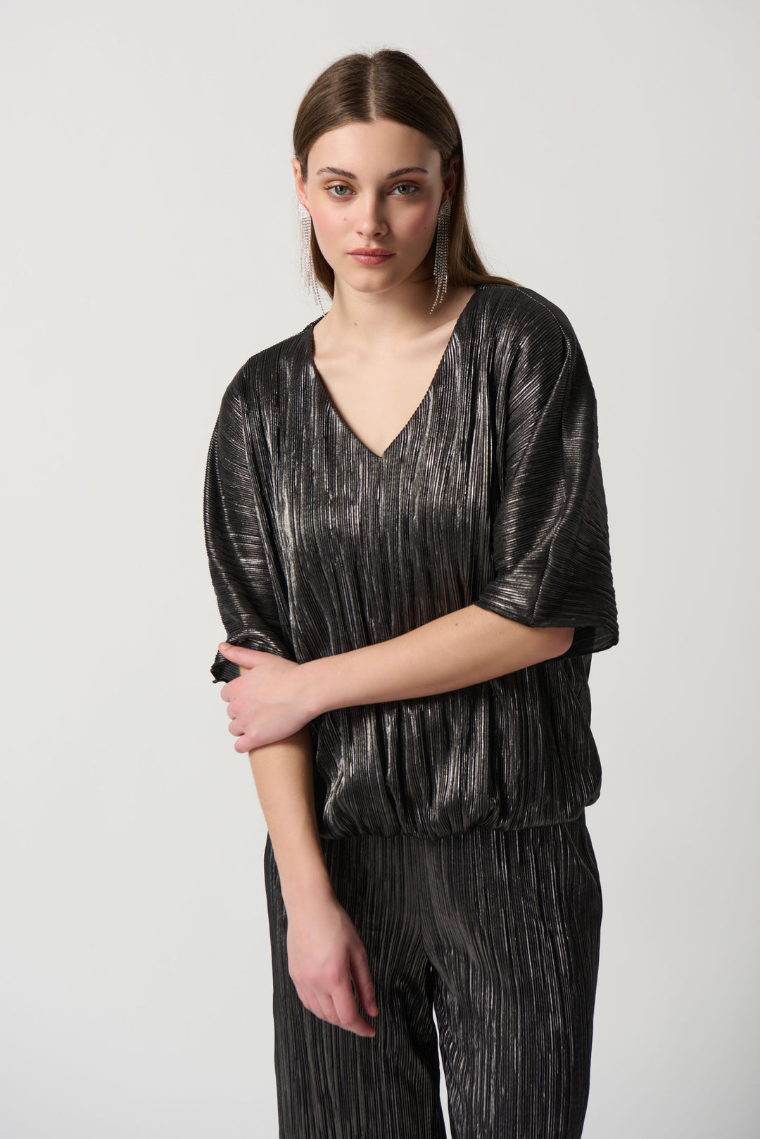 Crafted from a shimmery metallic style fabric with a silvery sheen, this top features a deeper v-neck and 3/4 length sleeves for a classy look. 