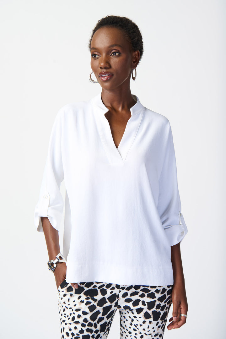 This unique top features a wide collar, front pockets and rolled tab sleeves. 
