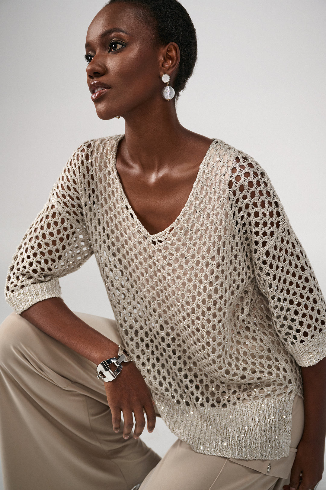 Joseph Ribkoff Spring 2024 Indulge in luxury with our crochet top featuring intricate sequin detailing.
