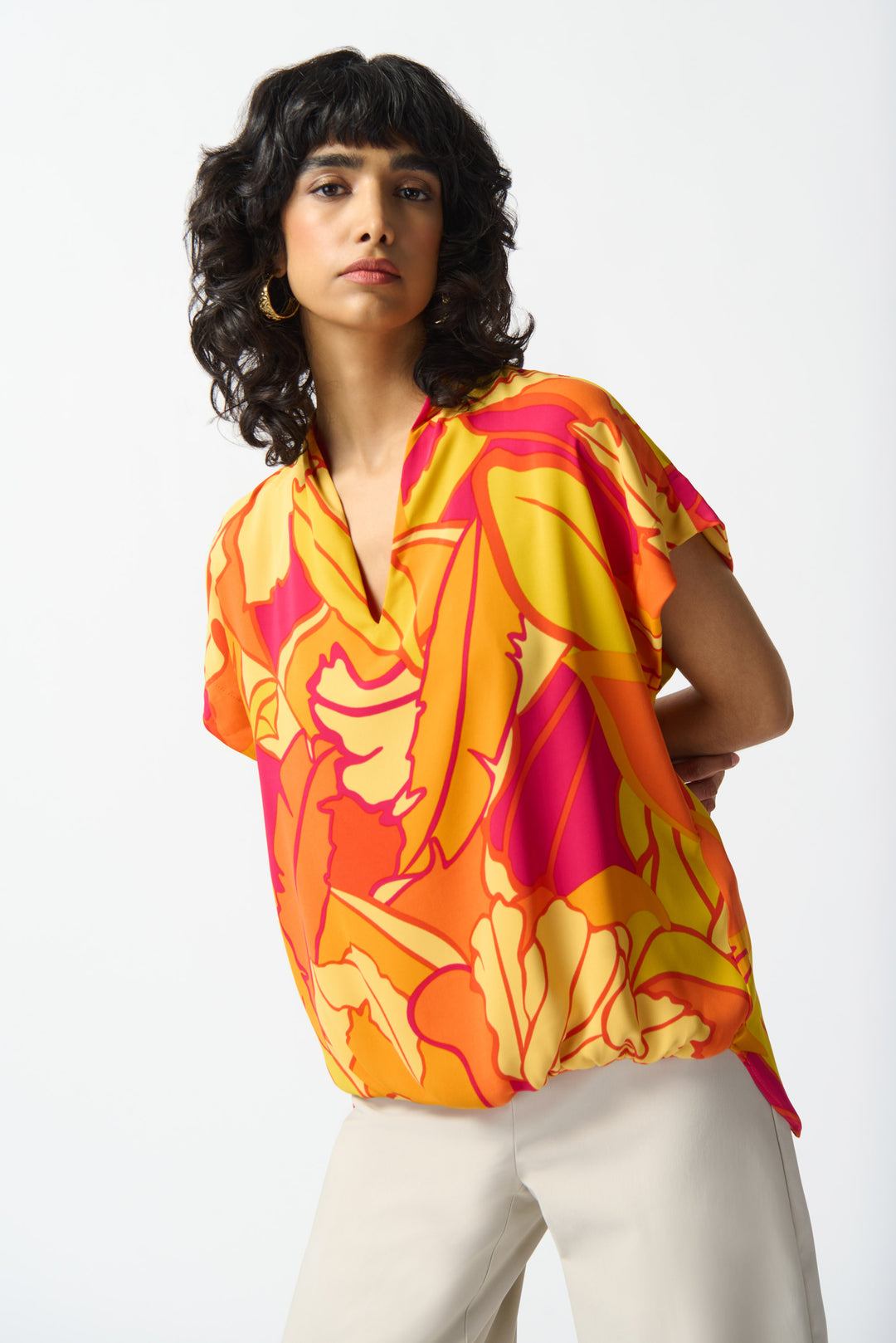 JOSEPH RIBKOFF Spring 2024 With a deep V-neckline and relaxed fit, this top features a tropical orange print, short sleeves and a loose, draped style.