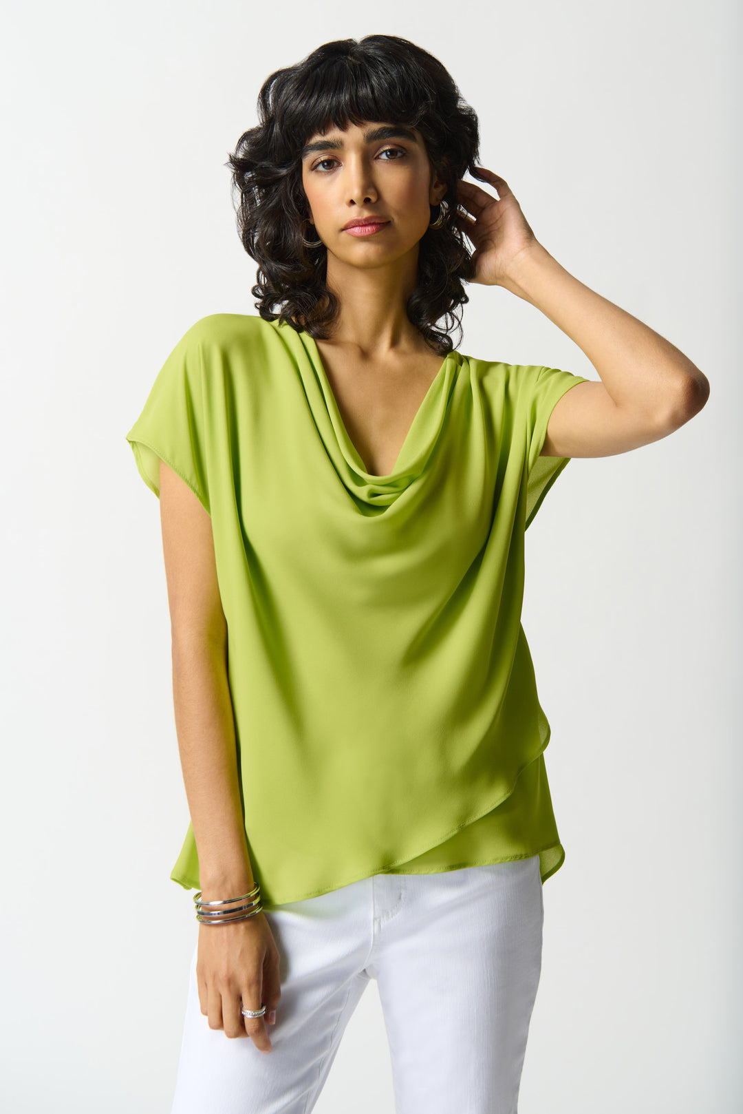 JOSEPH RIBKOFF Spring 2024 Featuring a satin sheen finish and layers of light, free-flowing fabric, this short sleeve top exudes elegance.