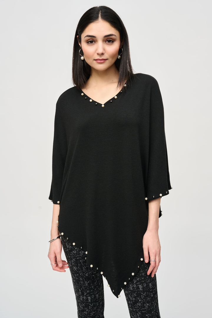 Joseph Ribkoff Fall 2024 This light and loose sweater knit poncho features a soft cut v-neck and 3/4 length sleeves. This statement piece is adorned with pearls and beads along the neckline and hem, adding a touch of elegance to any outfit.