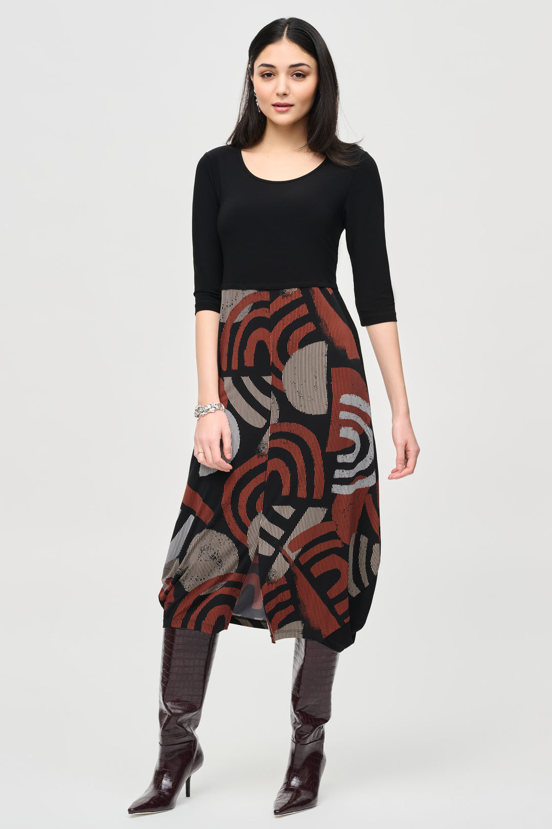 Joseph Ribkoff Fall 2024 Introducing our Geometric Print Cocoon Dress, featuring a midi length design with a sleek front slit cut. The neat geometric or abstract print adds a touch of elegance, while the skirt style and 3/4 straight sleeves provide comfort and versatility all season long.