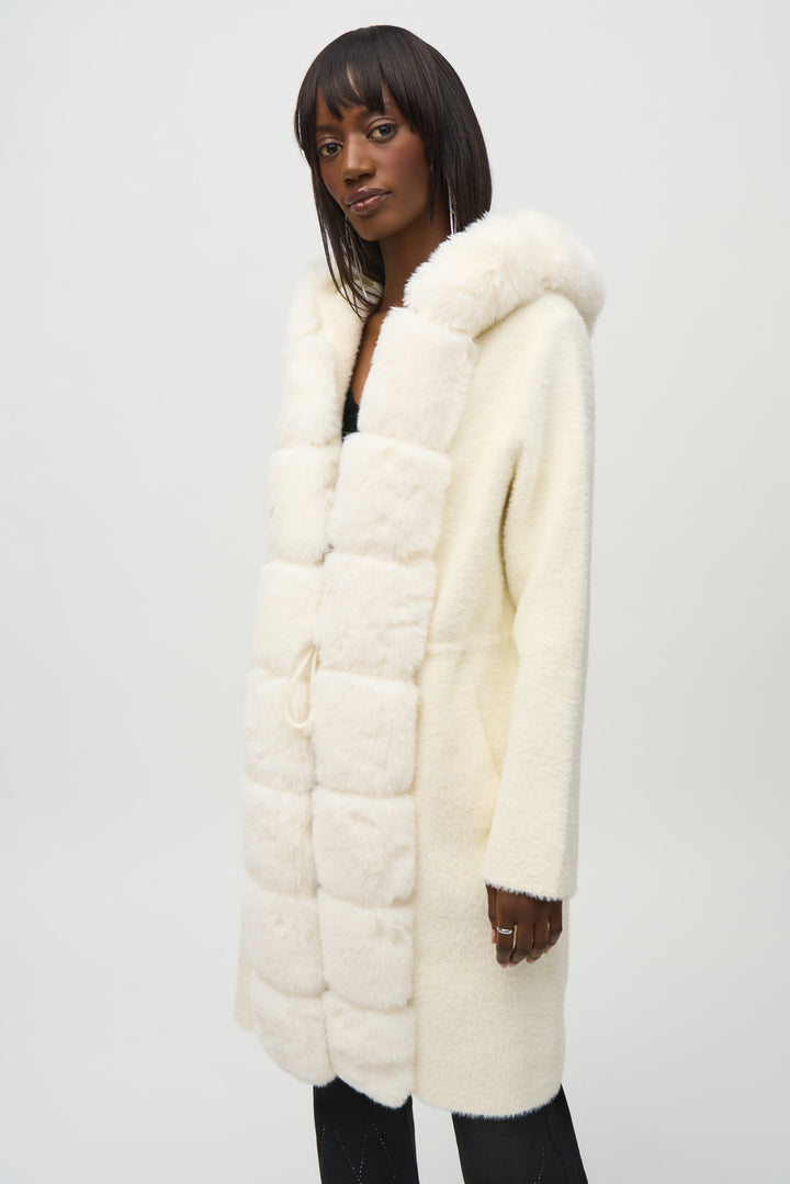 Joseph Ribkoff Fall 2024 Made with soft feather yarn and a warm faux fur hood, this sweater knit coat also features a drawstring for a customizable fit and convenient side pockets.