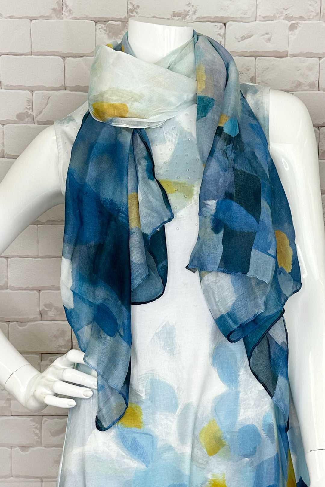 Dolcezza Spring 2024 This light and lovely woven scarf features a blue abstract print that pairs perfectly with all your summer Dolcezza favourites!
