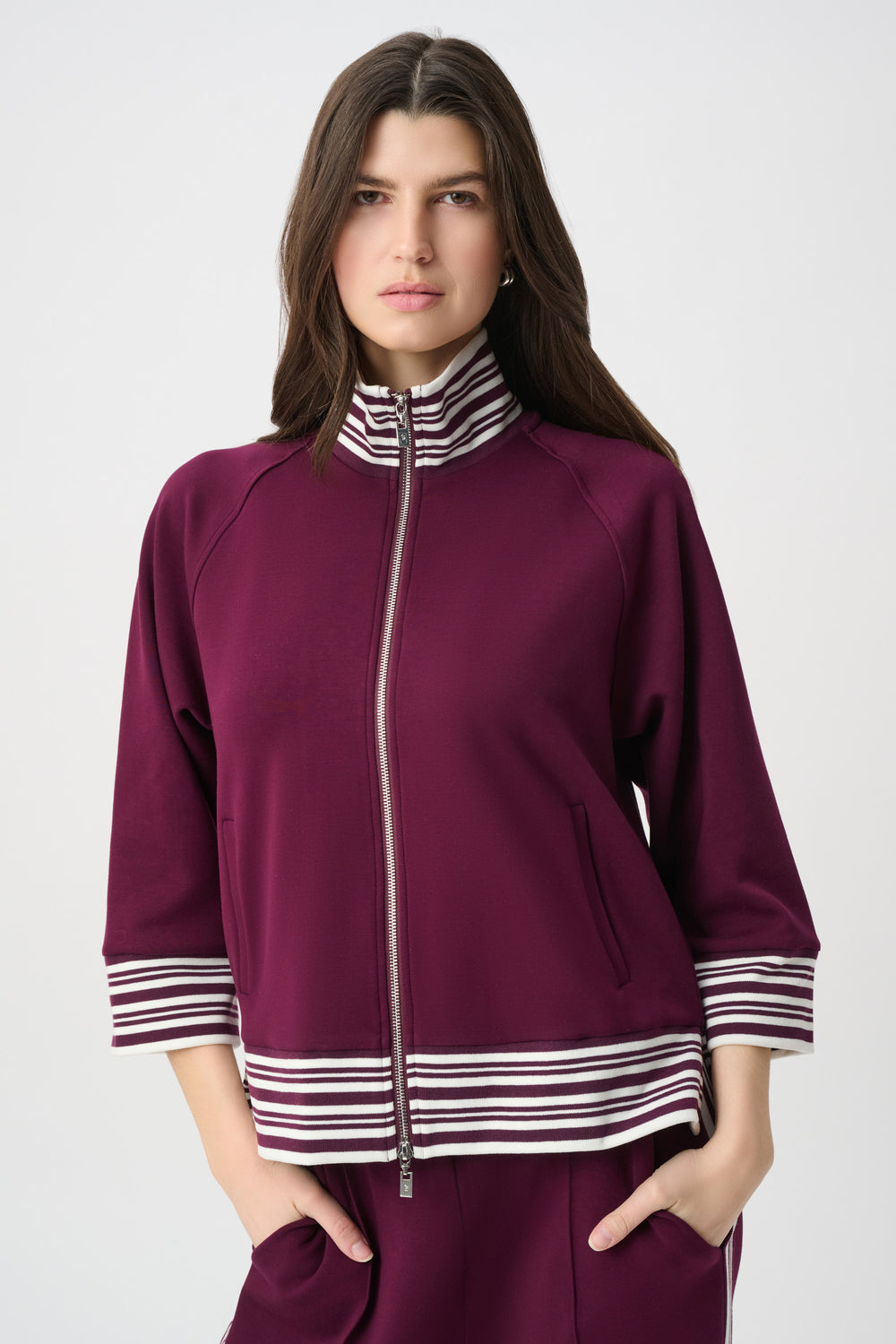 Woman wearing a purple outfit with striped details on a white background