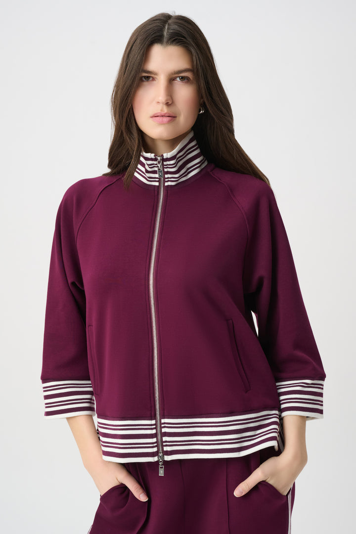 Woman wearing a purple outfit with striped details on a white background