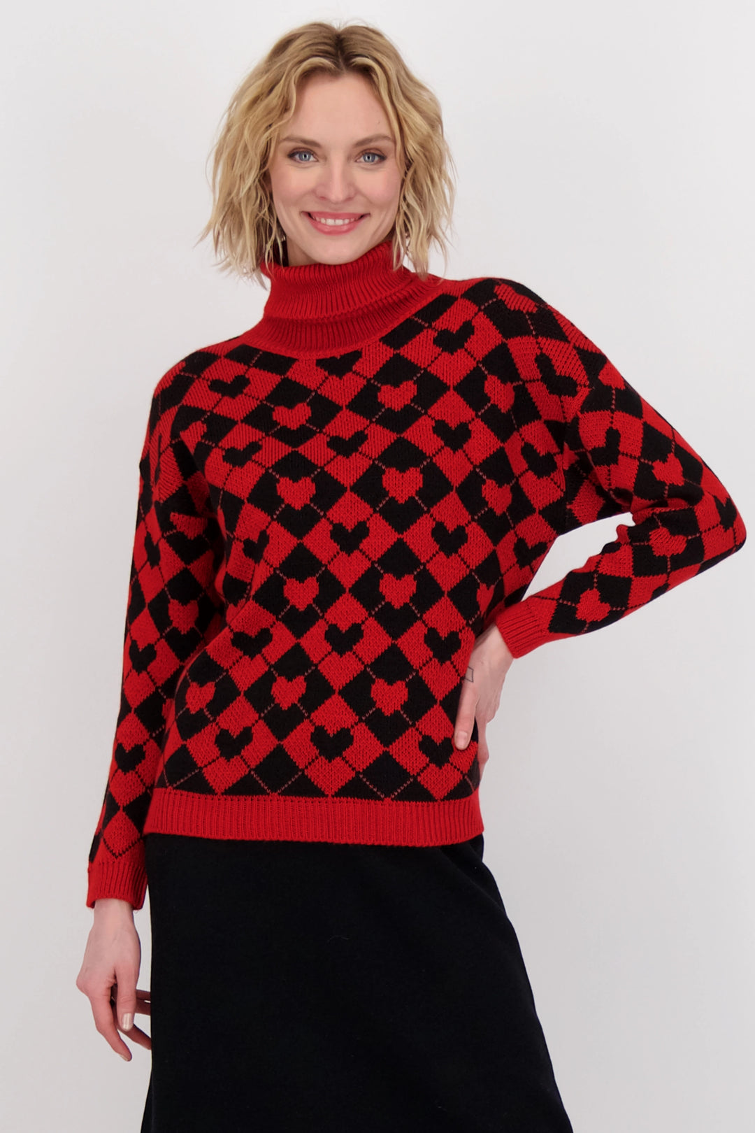 This comfy and stretchy light sweater features a stunning hearts print all-over with a plaid design. A bold red ribbed hem, cuffs and neckline complete the look.