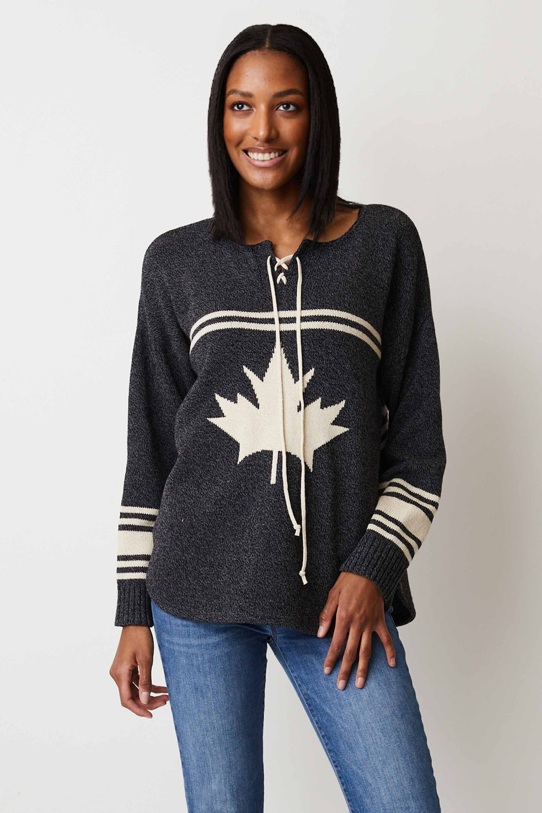 Cotton Country Fall 2024 With a loose fit and drawstring, it's both comfy and stylish. The design pattern on the sleeves and maple leaf print add a touch of hockey flair to this light sweater.