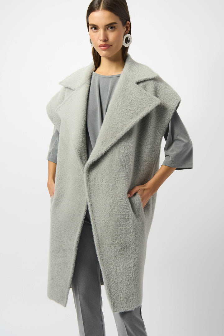 Joseph Ribkoff Fall 2025 
This light grey long vest redefines effortless sophistication with its chic, boxy silhouette and open front design. Crafted from delicate feather yarn, it offers a subtle textured feel that adds depth to your look.