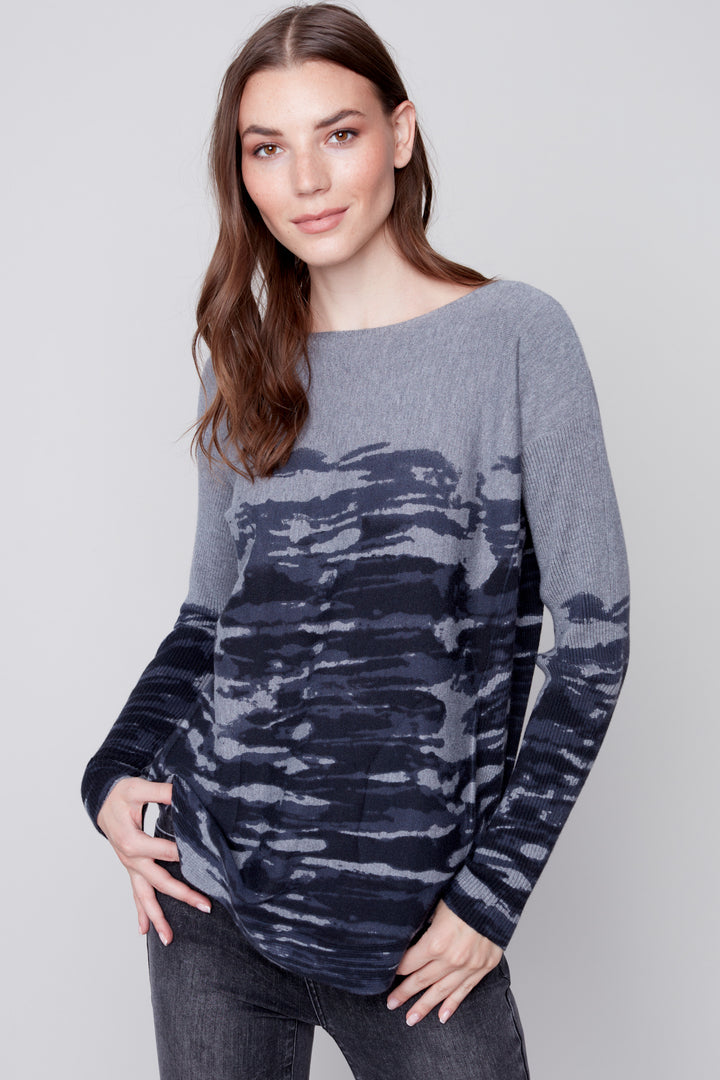 This Camo Stripe Long Sleeve Top is made of printed plush knit fabric, with two tone navy and charcoal colouring. Unique eyelet lace up detailing at the back adds a stylish flair. This top is designed for warmth and comfort, perfect for any casual or dressy event.