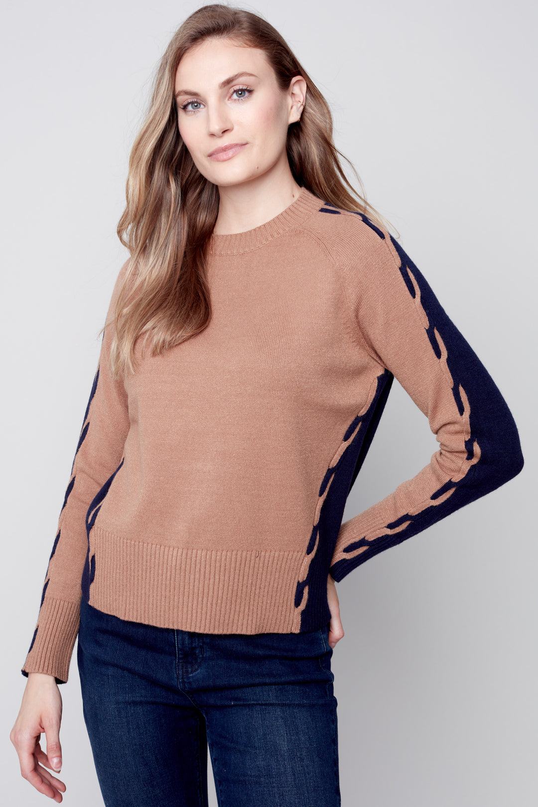 Stay warm and stylish with this plushy colour block knit sweater, featuring eye-catching cable detailing on the sleeves. 