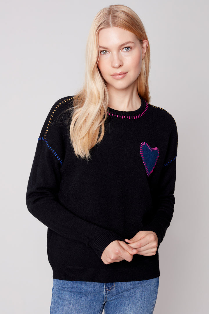 This ultra-soft sweater features a unique heart appliqué with contrast whipstitching and a classic crew neck for a look that is both stylish and comfortable. 