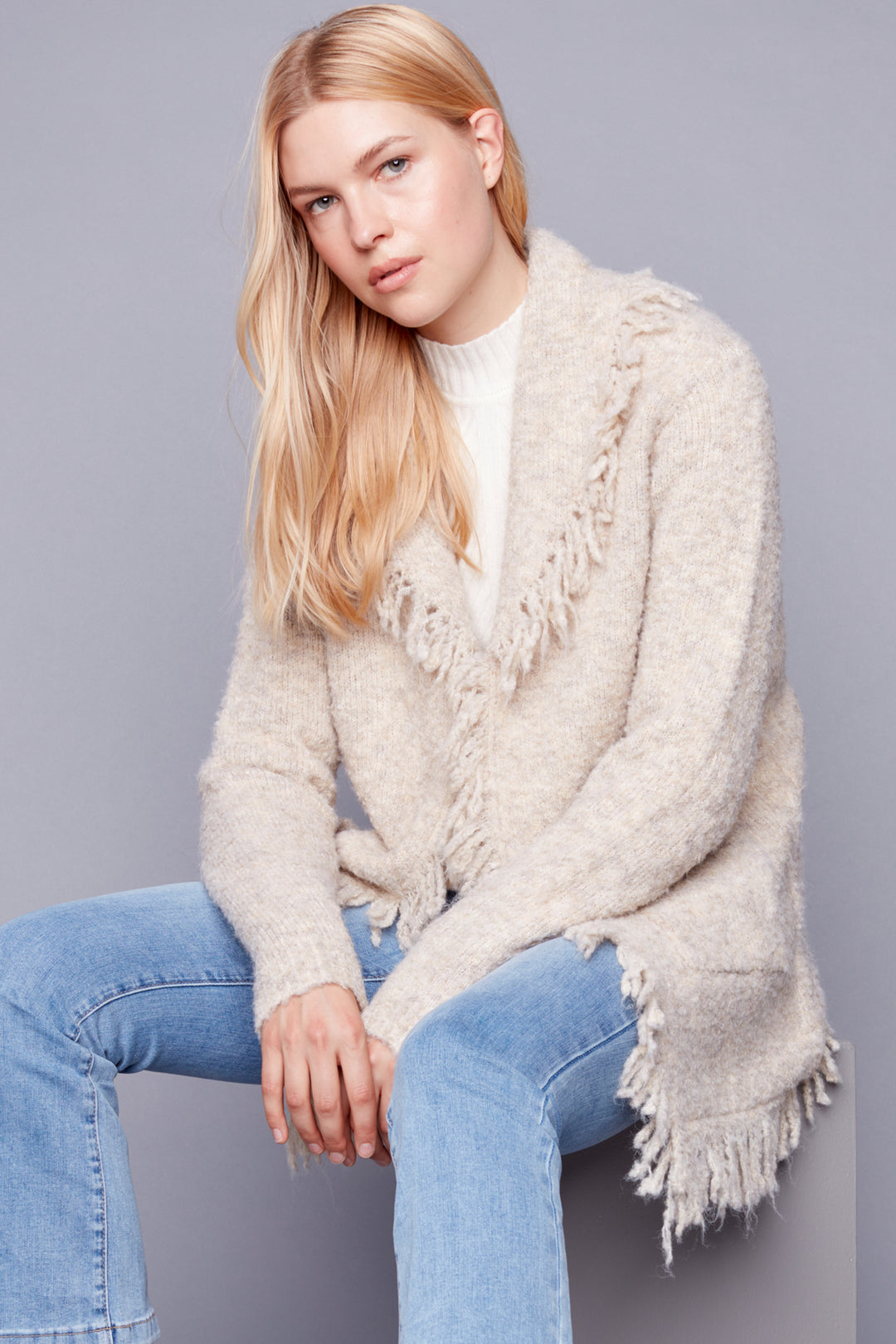 This new shawl-neck boucle knit cardigan features fluffy fringed edges and patch pockets. The light-weight construction and unique style provide a modern take on a classic design, while the soft fall tones make it perfect for autum season. 