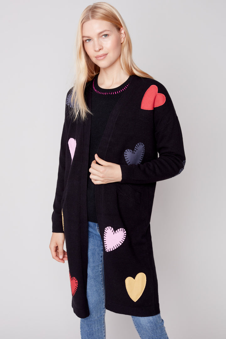 Its plushy fabric and heart-shaped appliqués add a touch of elegance and fun to any outfit. Be both cute and chic with this one of a kind cardigan sweater!