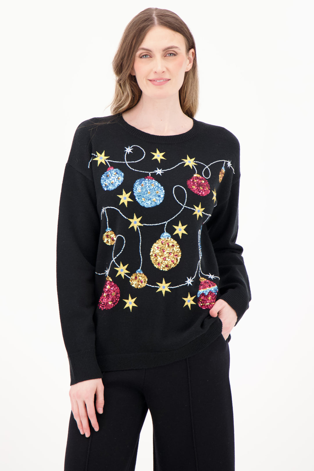 Woman wearing a black sweater with colorful Christmas ornament design on a white background