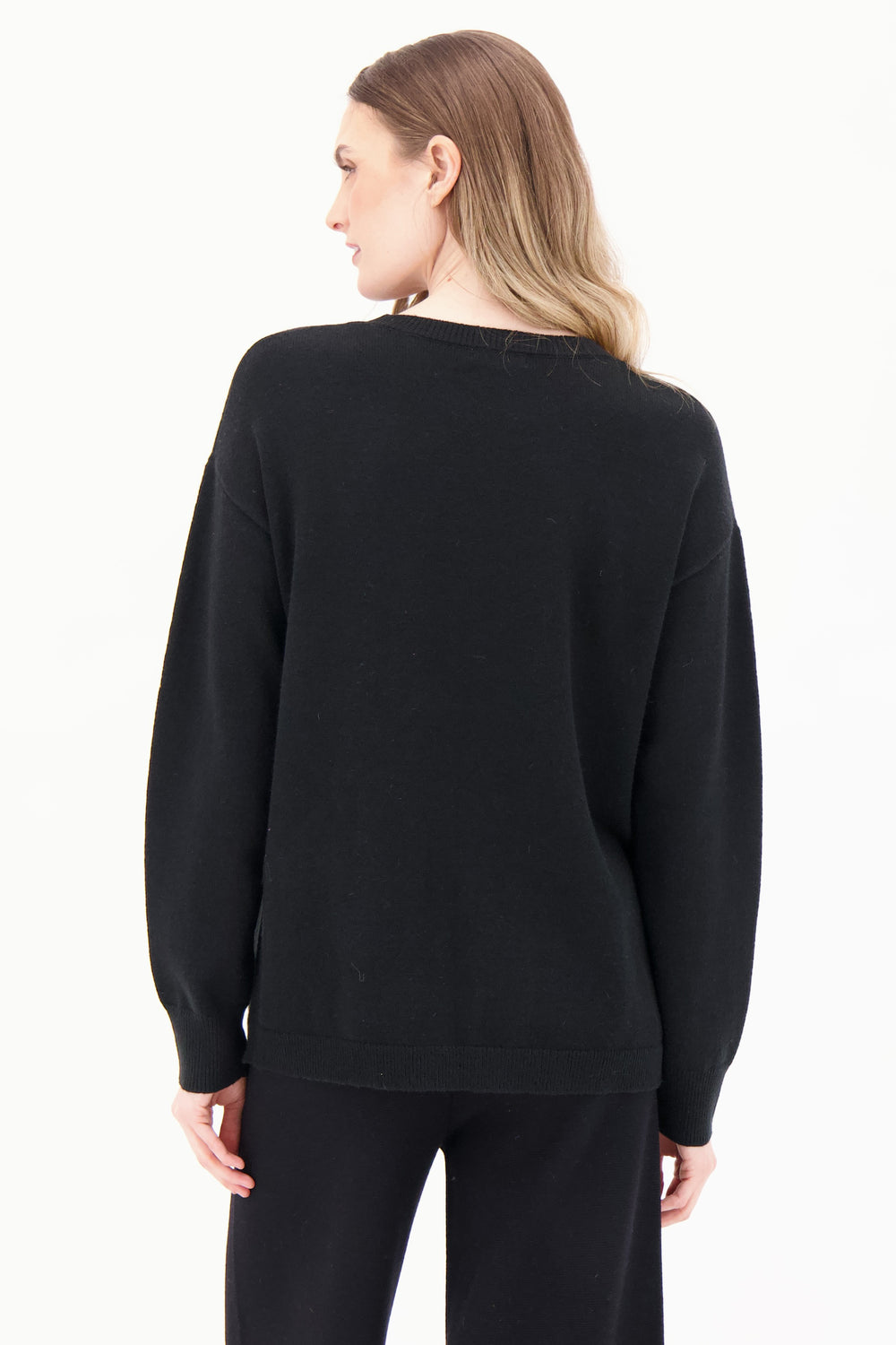 Person wearing a black sweatshirt and pants on a white background
