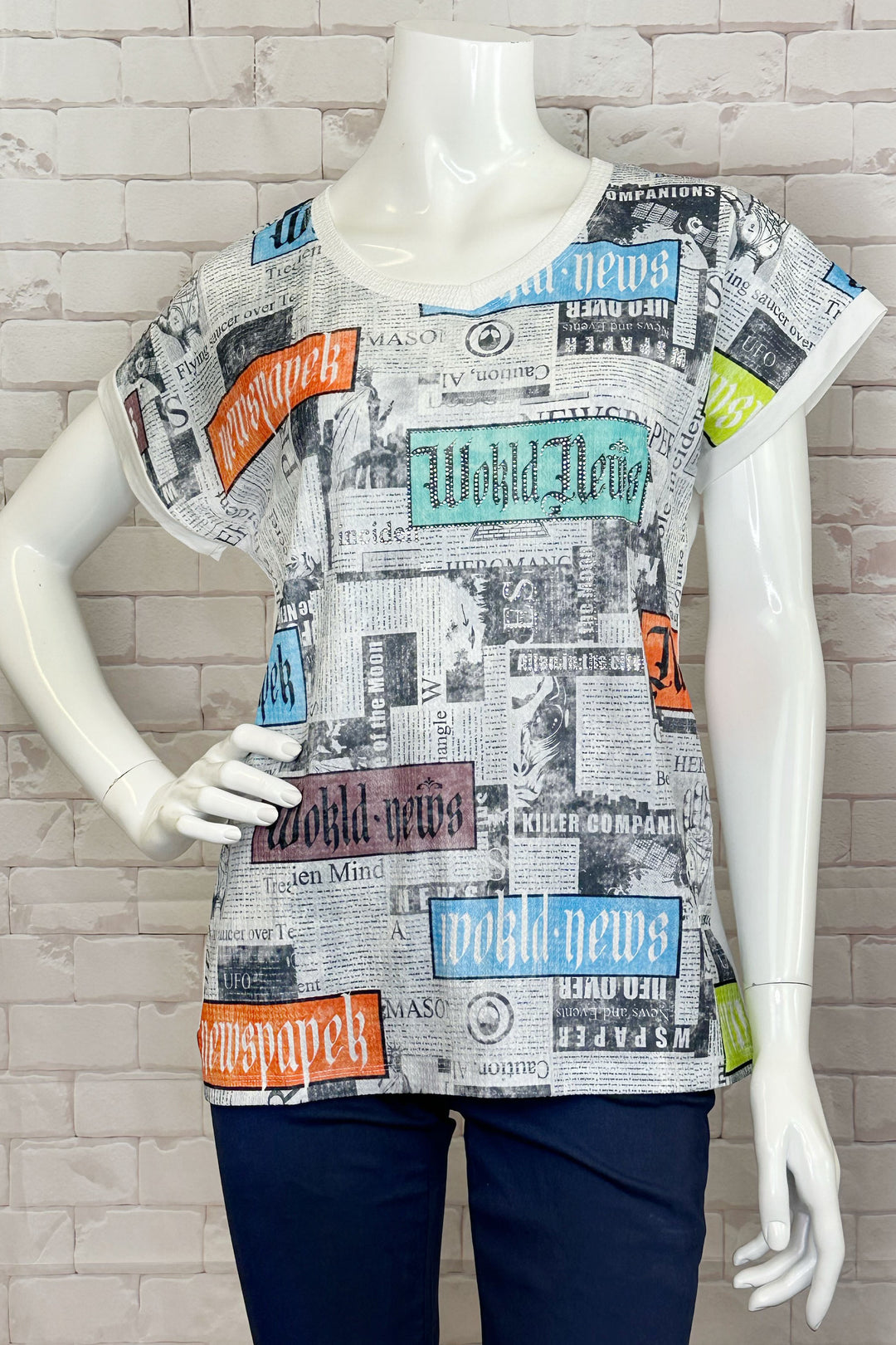 Ness Spring 2024 The soft cut v-neck and short sleeves make it easy and comfortable to wear, while the quriky newspaper print on the front adds a touch of fun and playfulness to any outfit.