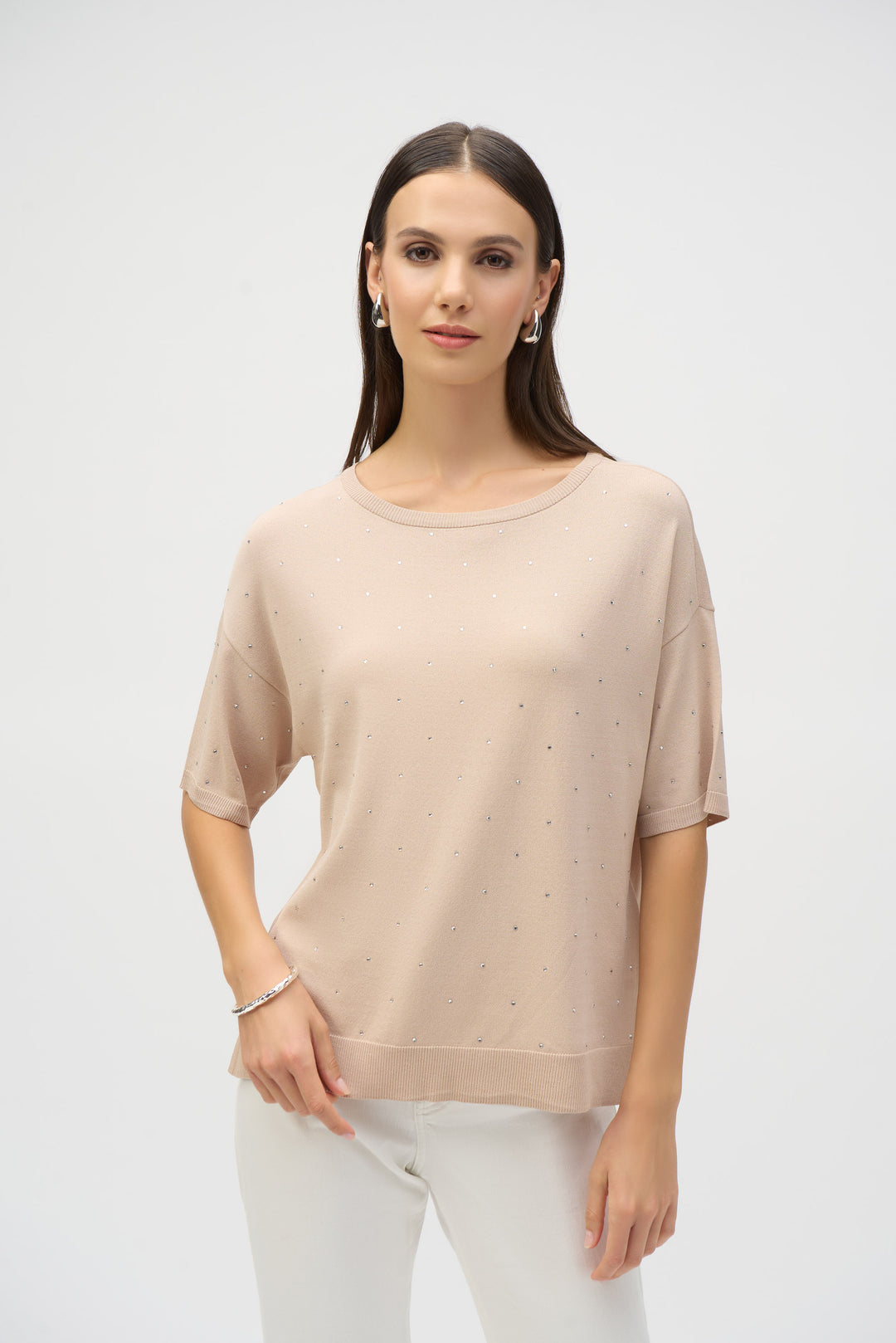 Joseph Ribkoff Spring 2025  With cute side slit cuts, crew neckline and relaxed fit, this sweater knit top is adorned with specs of bling on the front and sleeves, adding a touch of glamour! 