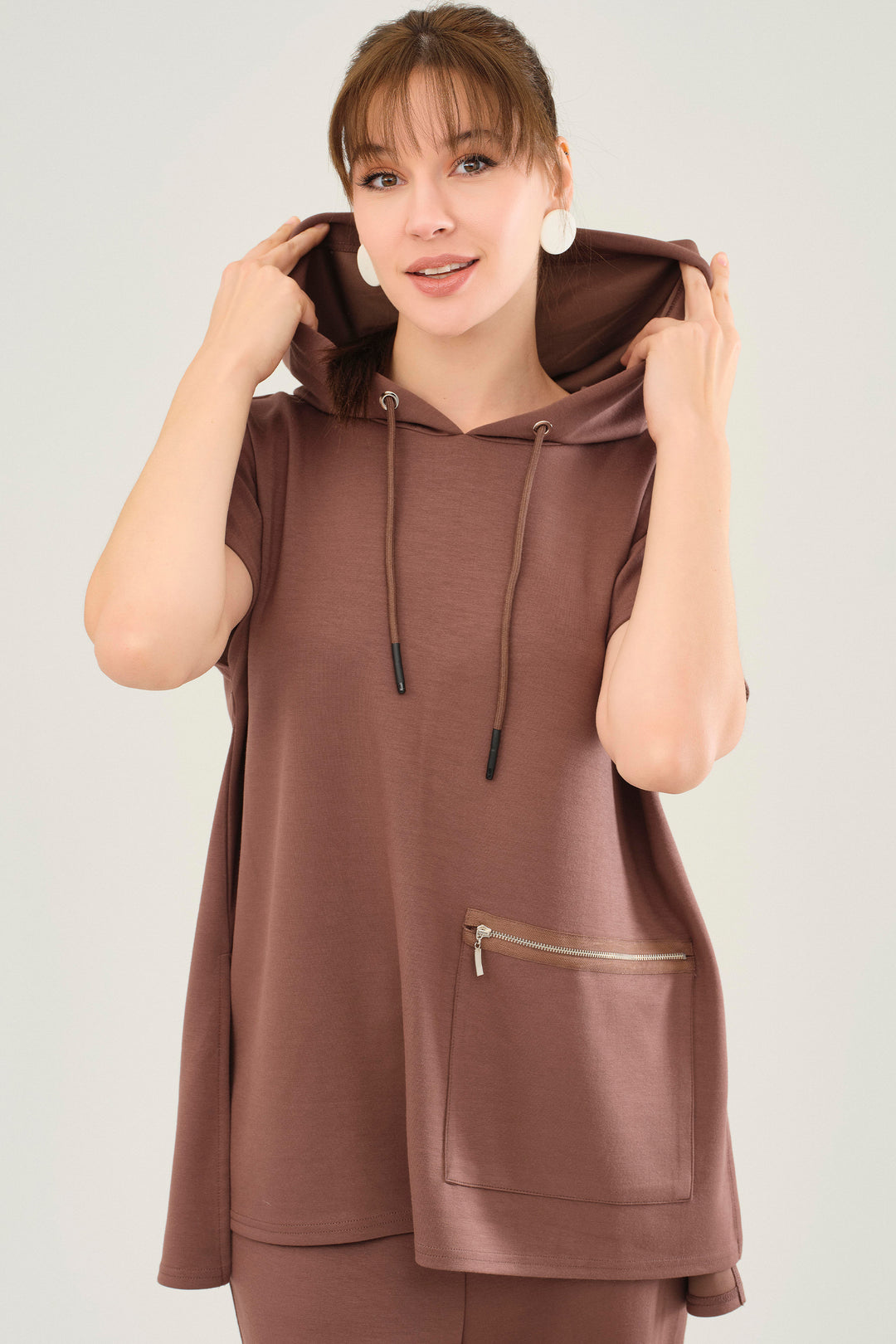 It is beautifully constructed with a luxe sweet chocolate hue and a hooded neckline. A large side pocket adds an extra touch of practicality, while the lower back hem provides a figure-flattering looser fit. 