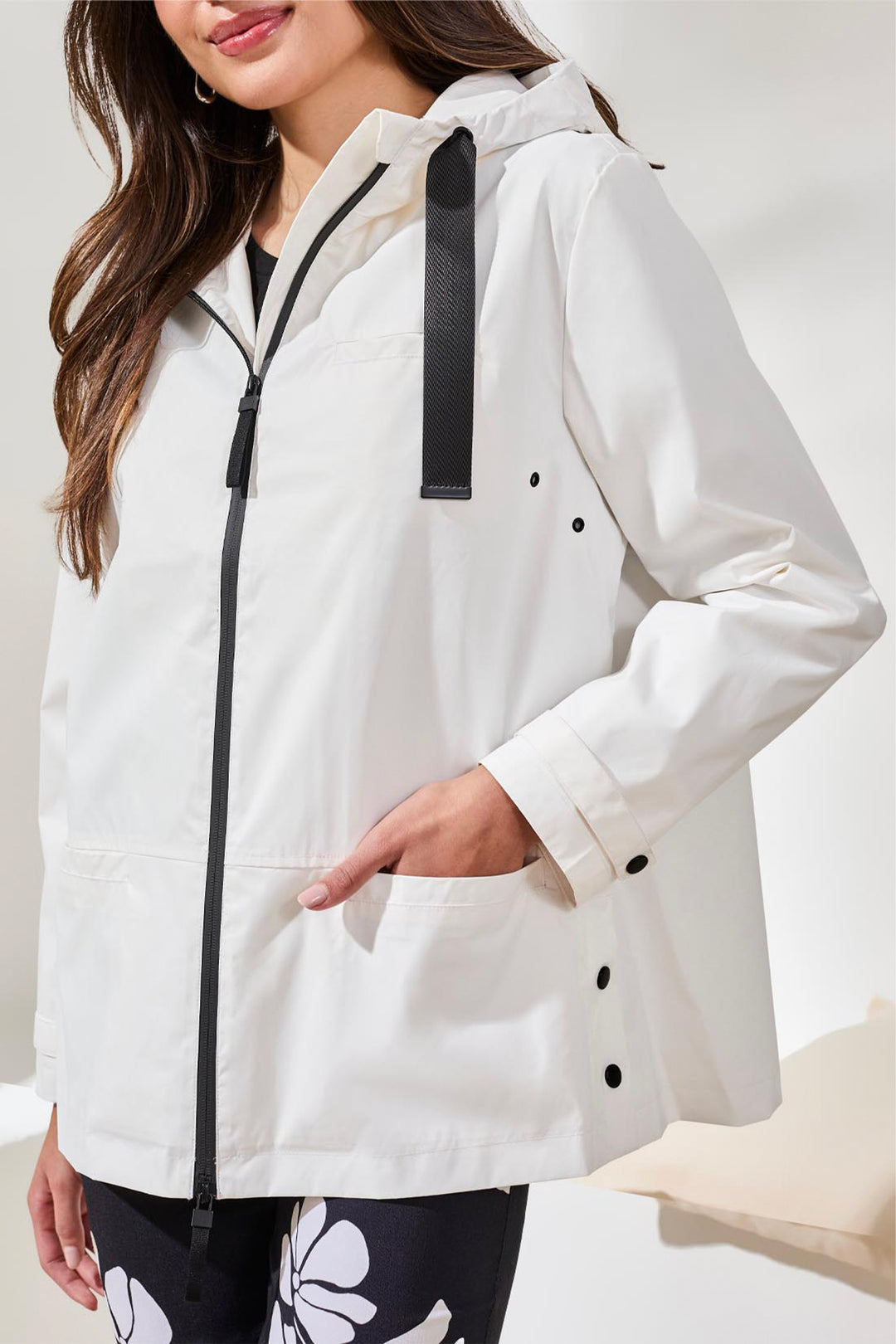 White raincoat with black accents worn by a person on a white background